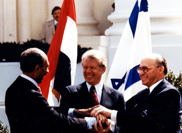 Menachem Begin and Anwar as-Sādāt signing the Israel-Egypt peace agreement, mediated by US President Jimmy Carter.